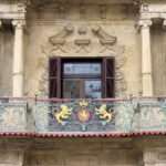 Balcón de forja con leones dorados y escudo en la fachada barroca de la Casa Consistorial de Pamplona-Iruña.