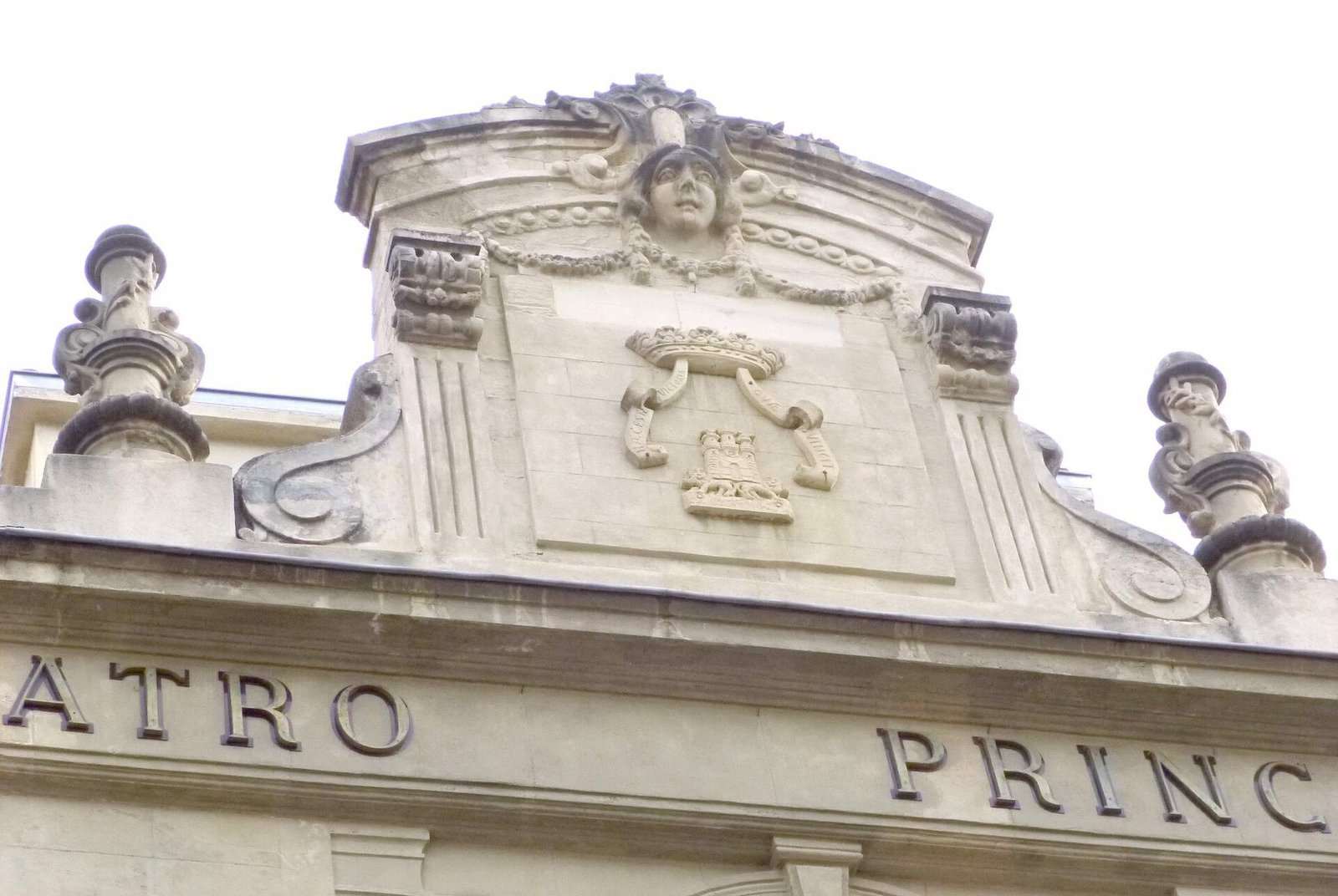 Frontón de piedra con escudo, mascarón y letras «TRO PRINC» en la fachada del Teatro Principal de Vitoria